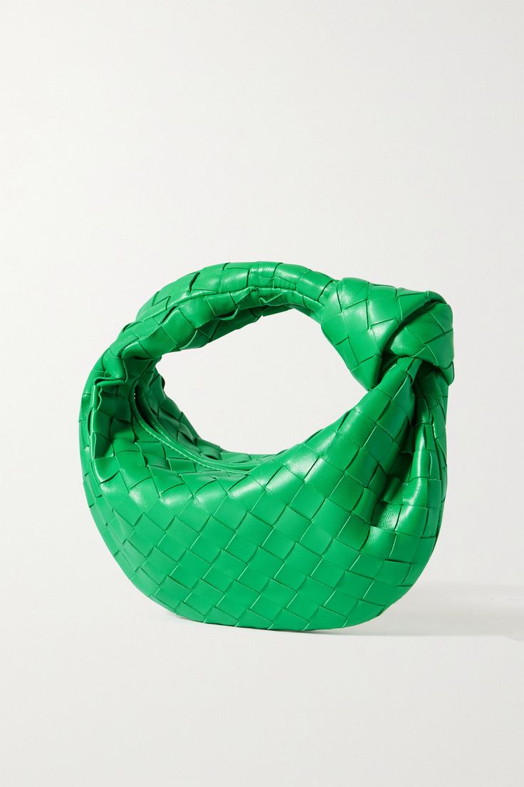 Green woven handbag on a white background