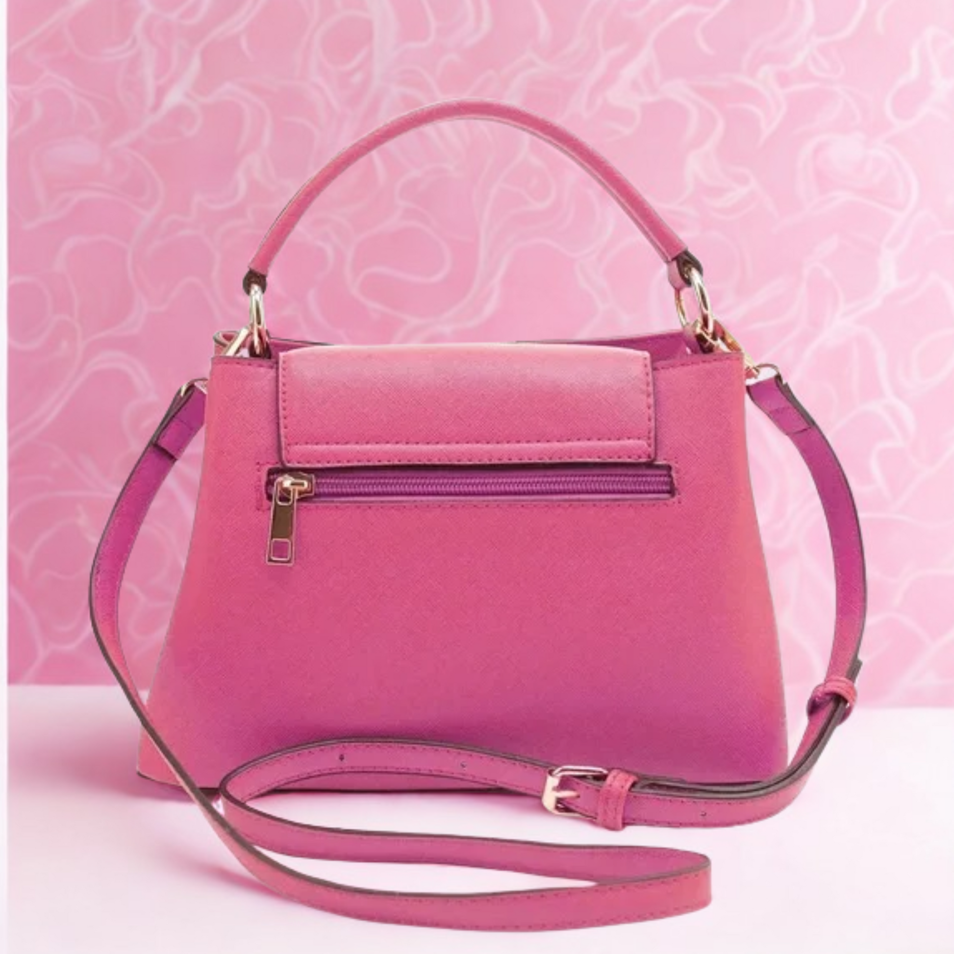 Pink handbag with a strap on a pink background