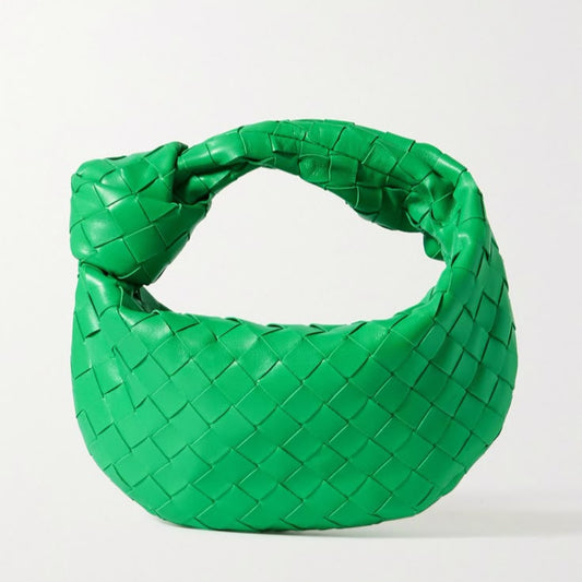 Green woven handbag on a white background